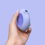 Lumii suction vibrator by Biird in color purple with hand